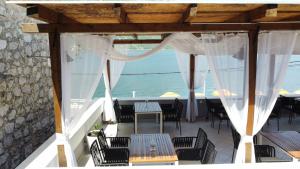 a patio with a table and chairs and the ocean at Hotel Lavanda in Donja Kostanjica