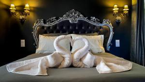 two swans wrapped in towels sitting on a bed at NOUVEAU - LUXURE - Secret Suite - JACUZZI in Melun