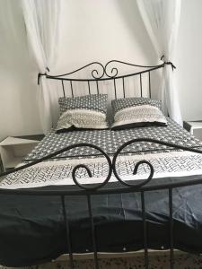 łóżko z czarną ramą i poduszkami w obiekcie Agréable maison au cœur du village w Argelès-sur-Mer