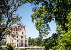 duży biały dom z drzewami przed nim w obiekcie Agréable maison au cœur du village w Argelès-sur-Mer