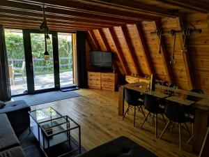 a living room with a table and chairs in a cabin at Jodłowy Zakątek NEW in Niechorze