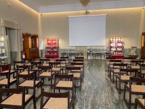 Pokój ze stołami i krzesłami z dużym ekranem w obiekcie Hotel Vittoria w mieście Faenza