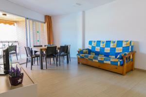 a living room with a couch and a table and chairs at Rentalmar Mas d'en Gran in Cambrils