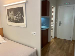 een kamer met een bed en een foto aan de muur bij Apartamentos León in León +19 foto's