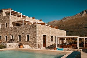 a stone house with a swimming pool in front of it at Itilo Traditional Hotel in Neo Itilo