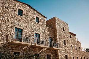 - un bâtiment en pierre avec des balcons sur le côté dans l'établissement Itilo Traditional Hotel, à Neon Oitilon