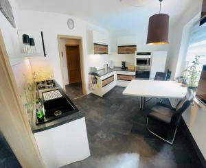 une cuisine avec une table et un comptoir blanc dans l'établissement Ferienwohnung Ziegenschweiz, à Auerbach