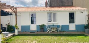 a white and blue house with a table and chairs at Studio indépendant 30m2 4 pers chez l'habitant Quartier des Roses in Les Sables-d'Olonne