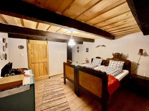 1 dormitorio con 2 camas y puerta de madera en Saschiz 130/Lodging and Glamping, en Saschiz