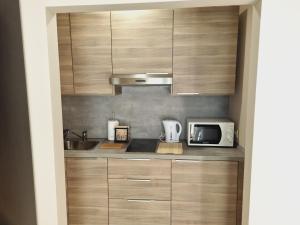 a kitchen with wooden cabinets and a microwave at Studio apartment Gemelli in Poreč