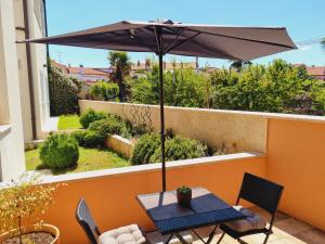 a table with an umbrella on a balcony at Studio apartment Gemelli in Poreč