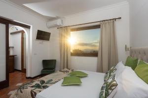 een slaapkamer met een bed en een raam met uitzicht op de zonsondergang bij Villa Aurora Pool & Fitness in Anacapri