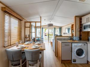 a kitchen and dining room with a table and chairs at Pass the Keys Luxury brand new 2 bedroom pet friendly caravan in Wimborne Minster