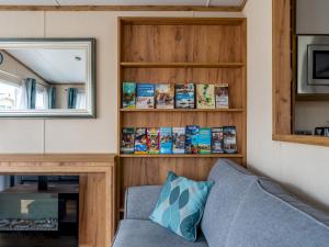a living room with a couch and a book shelf at Pass the Keys Luxury brand new 2 bedroom pet friendly caravan in Wimborne Minster