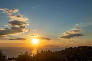 a sunset over the ocean with the sun in the sky at Villa Aurora Pool & Fitness in Anacapri
