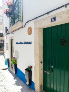 a green door on the side of a building at Residenza Dutzu - Aparthotel Leiria in Leiria