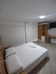 Horto Executivo Hotel في إيباتينجا: غرفة نوم مع سرير أبيض كبير في غرفة
