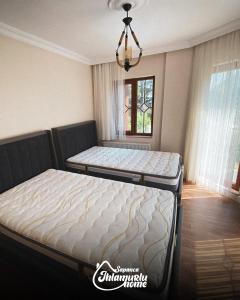 two twin beds in a bedroom with a chandelier at Ihlamurlu Home in Sapanca