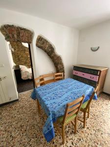 una camera con letto, tavolo e sedie di FONTANA’S HOUSE RELAX n.7 010065-LT-0009 a Valbravenna