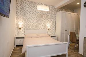 a bedroom with a white bed and two tables at Valletta Republic Suite in Valletta