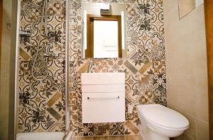 a bathroom with a toilet and a mirror at Valletta Republic Suite in Valletta