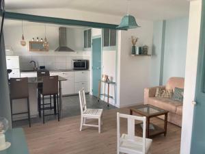 a living room and kitchen with a couch and a table at Studio indépendant 30m2 4 pers chez l'habitant Quartier des Roses in Les Sables-d'Olonne