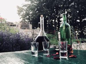 a bottle of wine and two glasses on a table at Grand Rabbit House on the Hillock in Žabljak