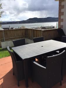 a table and chairs with a view of the water at Tigh mo Ghraidh ( House of my love) in Inverness