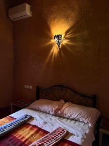um quarto com uma cama com uma borboleta na parede em La Fibule D'or em Aït-Ben-Haddou