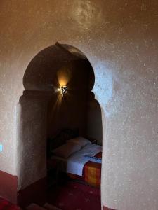 a bedroom with a bed in an arch way at La Fibule D'or in Aït Benhaddou