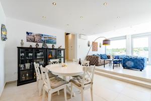 a dining room and living room with a table and chairs at Suartini Apartmani Račišće in Račišće