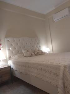 a bedroom with a white bed with two lamps at Villa Elli in Olympic Beach