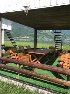 a picnic table and chairs under a pavilion with a lake at Begov kamp, Plav in Plav