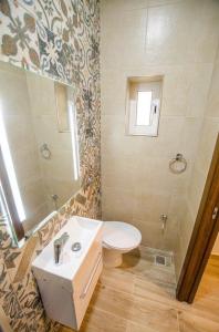 a bathroom with a toilet and a sink and a mirror at Valletta Republic Suite in Valletta