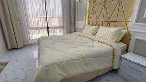 een slaapkamer met een groot bed met een houten hoofdeinde bij Al Jabal Resort Villa 3 in Salalah