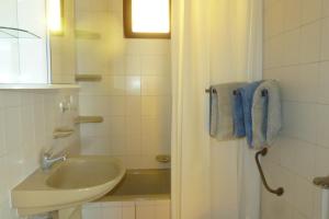 La salle de bains est pourvue d'un lavabo et d'une douche. dans l'établissement Labdarozsa Apartmanhouse, à Fonyód