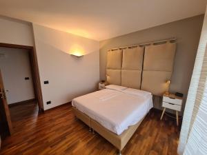 Schlafzimmer mit einem großen weißen Bett und Holzböden in der Unterkunft Bed & Breakfast Rezzonico in Bassano del Grappa