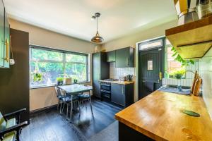 a kitchen with green cabinets and a table in it at Pass the Keys Little Leyton Garden Flat in London