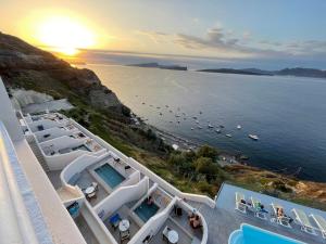 a view of a beach and the ocean at sunset at Kokkinos Villas in Akrotiri