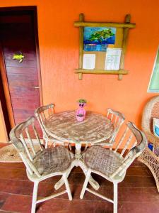 uma mesa com duas cadeiras e um vaso sobre ela em Casa Da Didda em Fernando de Noronha