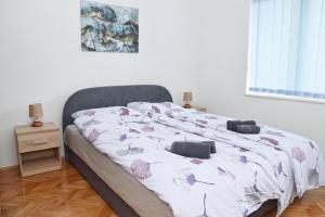 a bedroom with a bed with a floral bedspread at Apartman Palace Jajce in Jajce