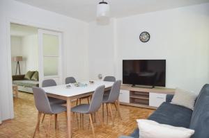a living room with a table and chairs and a tv at Apartman Palace Jajce in Jajce