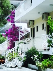 a white building with flowers on the stairs at Avra Ηouse in Kriopigi