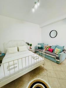um quarto com uma cama branca e um sofá em Anastasia’s House em Kissamos