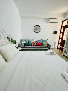 a white living room with a couch and a bed at Anastasia’s House in Kissamos