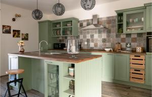 a kitchen with green cabinets and a counter with a sink at Lovely Home In Medulin With Wifi in Medulin