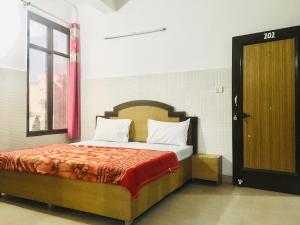 a bedroom with a bed and a window and a door at Trimrooms Shree Mata Palace, Katra Bus Stand in Katra