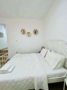 a white bed with white pillows in a bedroom at Anastasia’s House in Kissamos