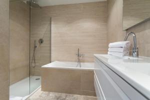 a bathroom with a tub and a sink and a shower at Villa Velvet in Villeneuve-Loubet