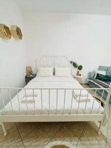 uma cama branca num quarto branco com uma estrutura de cama em Anastasia’s House em Kissamos
